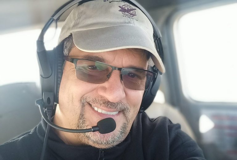 Mann in Warnweste posiert vor einem Flugzeugtriebwerk auf dem Rollfeld.